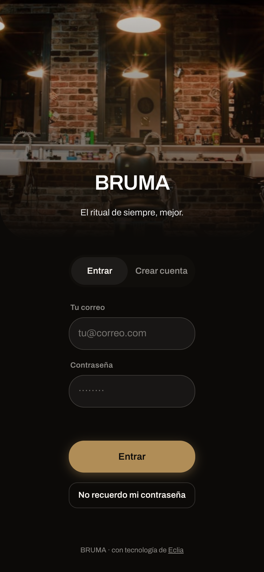 La app de una barbería en modo penumbra: grotesca, esquinas redondas, halo dorado.